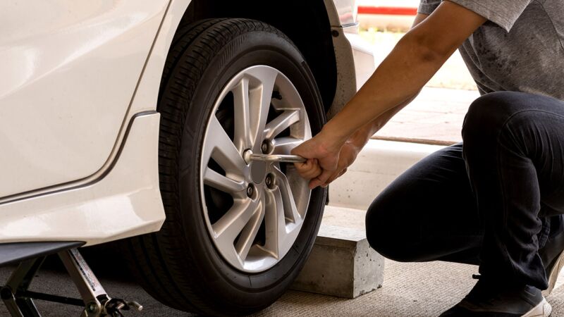 Auto Repairman Performing Mobile Flat Tire Repair and Change